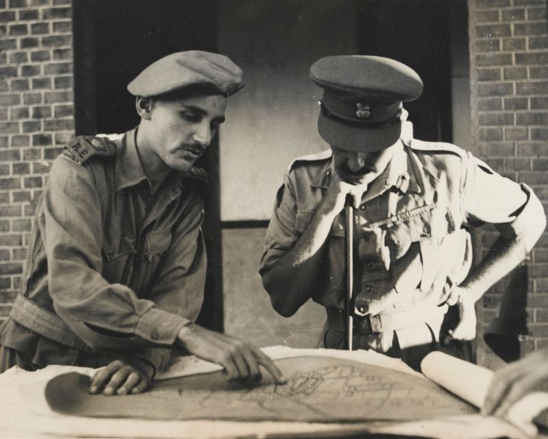 Two men look over a map.