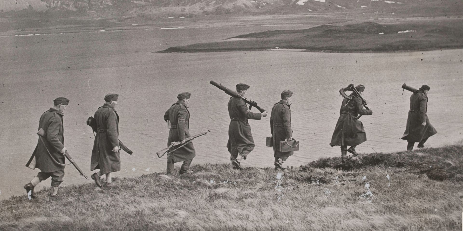Members of the Home Guard marching alongside a riverbank
