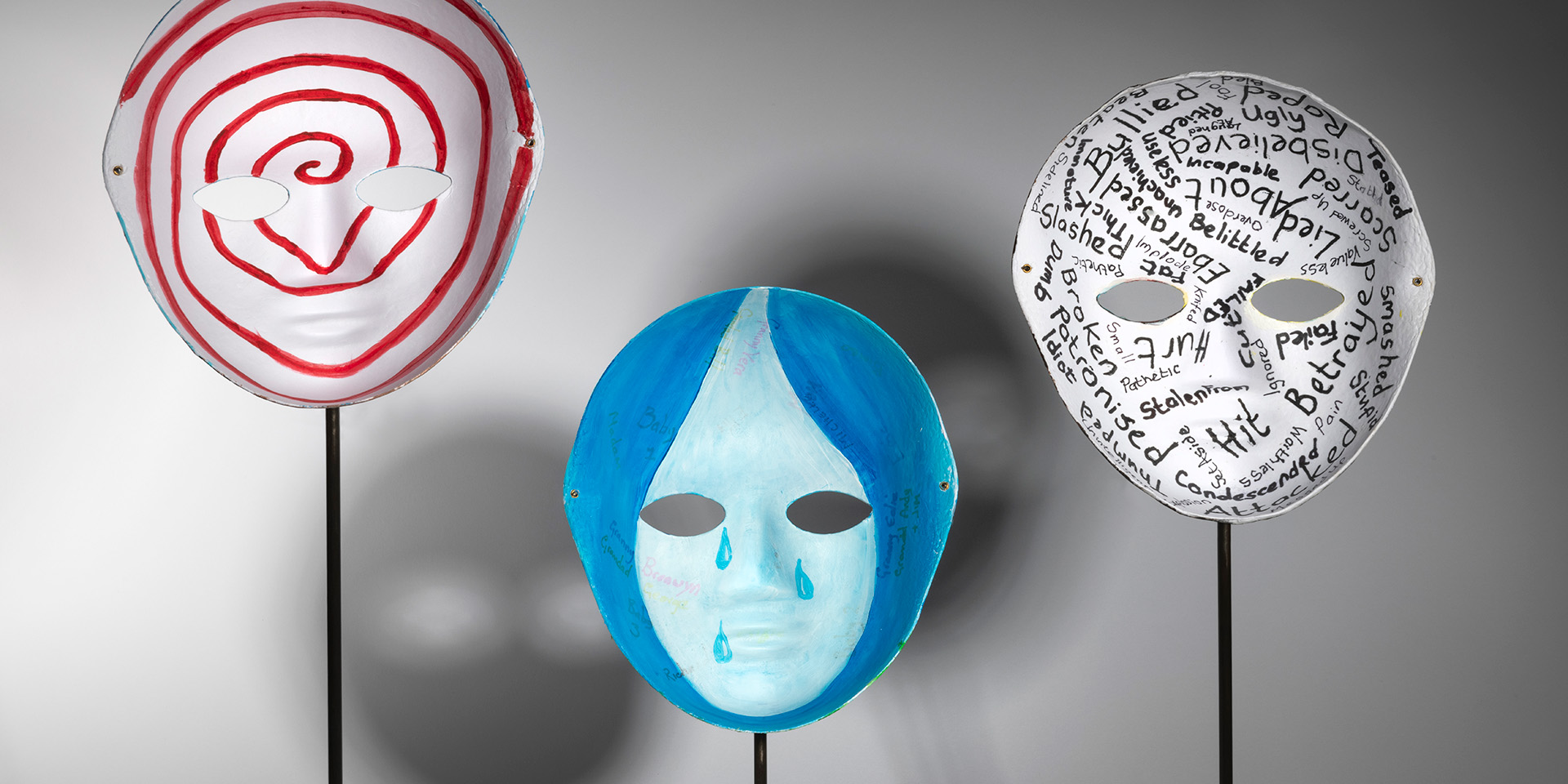 Three painted masks on display