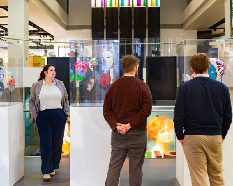 Museum visitors admiring masks on display.