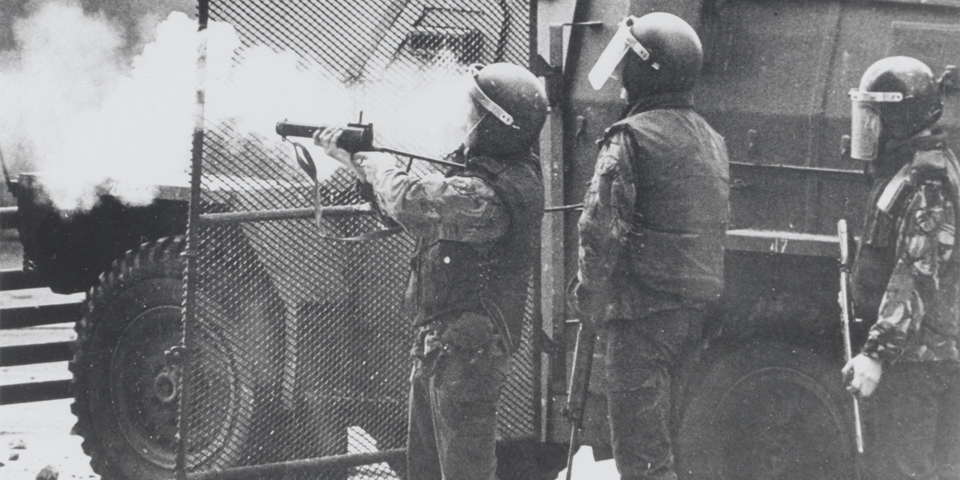 British soldiers in riot equipment standing next to a 'Humber Pig' truck, 1972