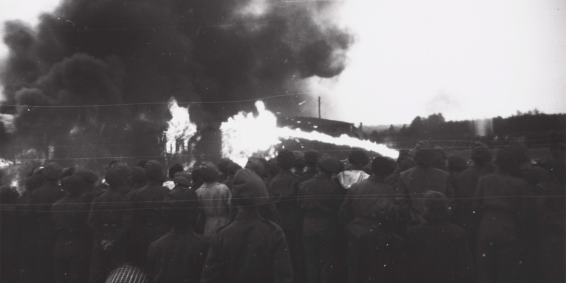 A crowd watching the Bergen-Belsen concentration camp burn down