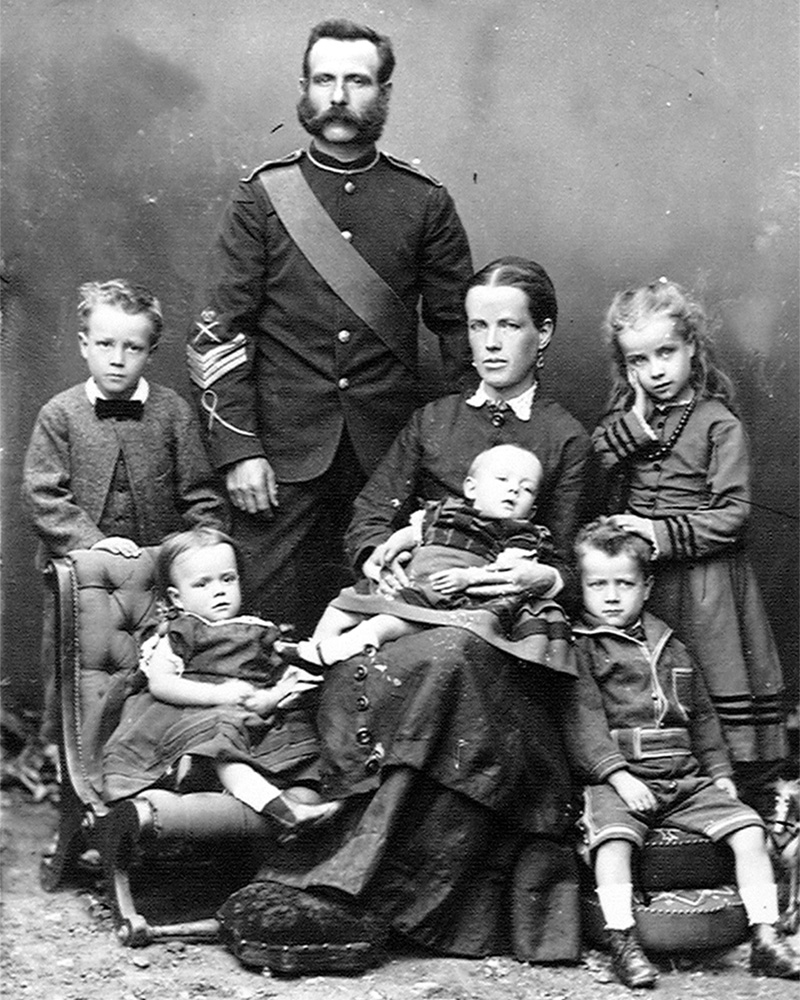 Family portrait photograph with a senior non-commissioned officer standing beside his seated wife and five children, c1875
