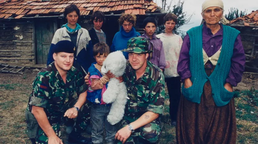 Soldiers with a refugee Kosovo Albanian family, 1999