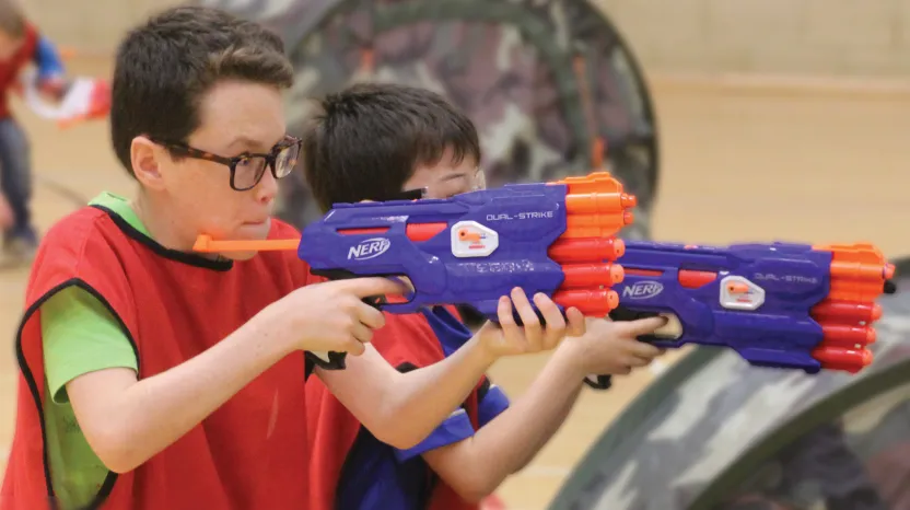 Children taking part in a Nerf gun battle