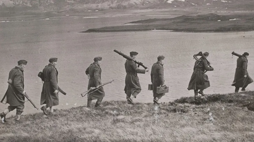 Members of the Home Guard marching alongside a riverbank