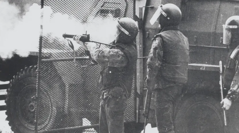 British soldiers in riot equipment standing next to a 'Humber Pig' truck, 1972