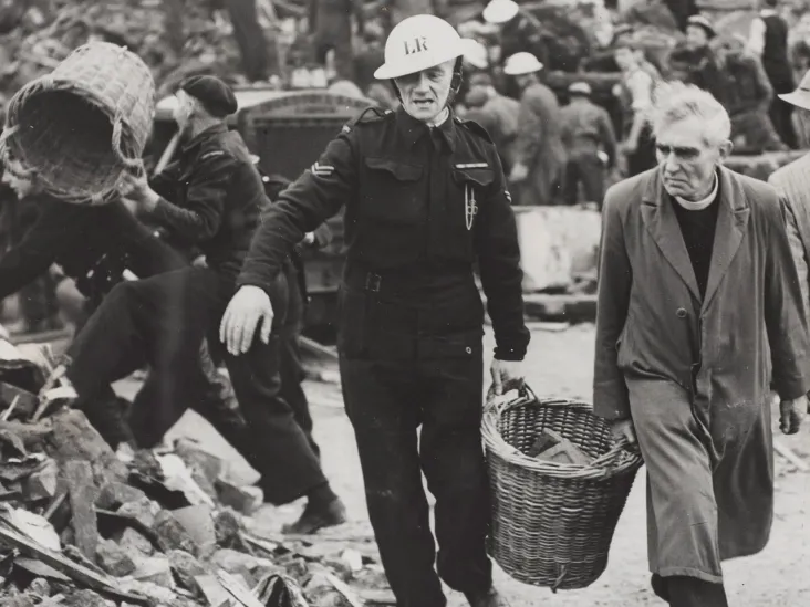 A clergyman and Civil Defence workers helping to clear the debris of a London school, 1940