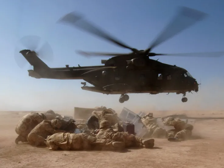 Soldiers huddle under helicopter