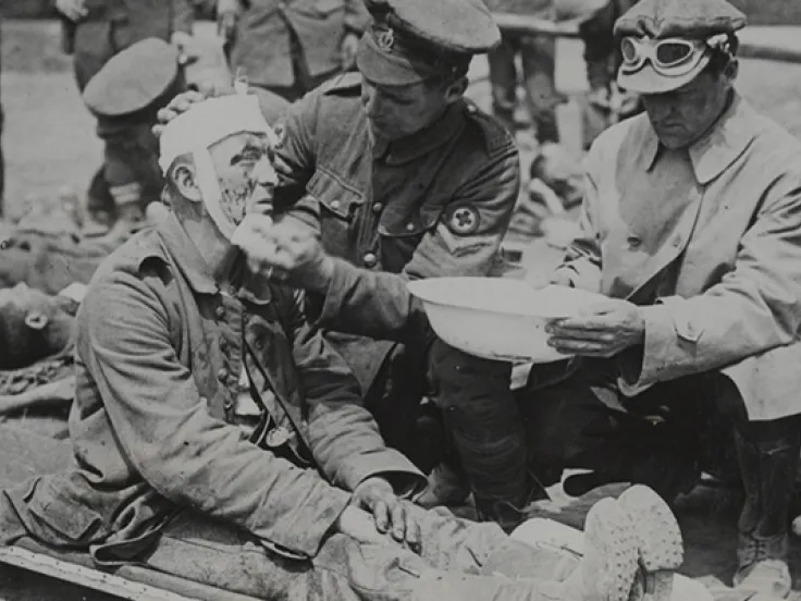 A British medical orderly treats a wounded German soldier, c1916