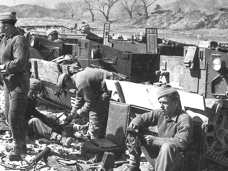 Members of 1st Battalion, The Middlesex Regiment (Duke of Cambridge’s Own) rest next to their carriers in Korea, 1950