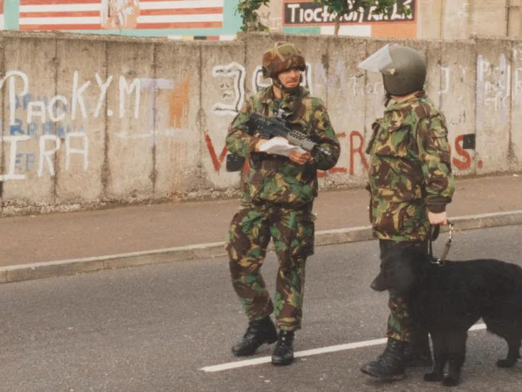 A bomb disposal officer and infantry officer patrol West Belfast, 1992