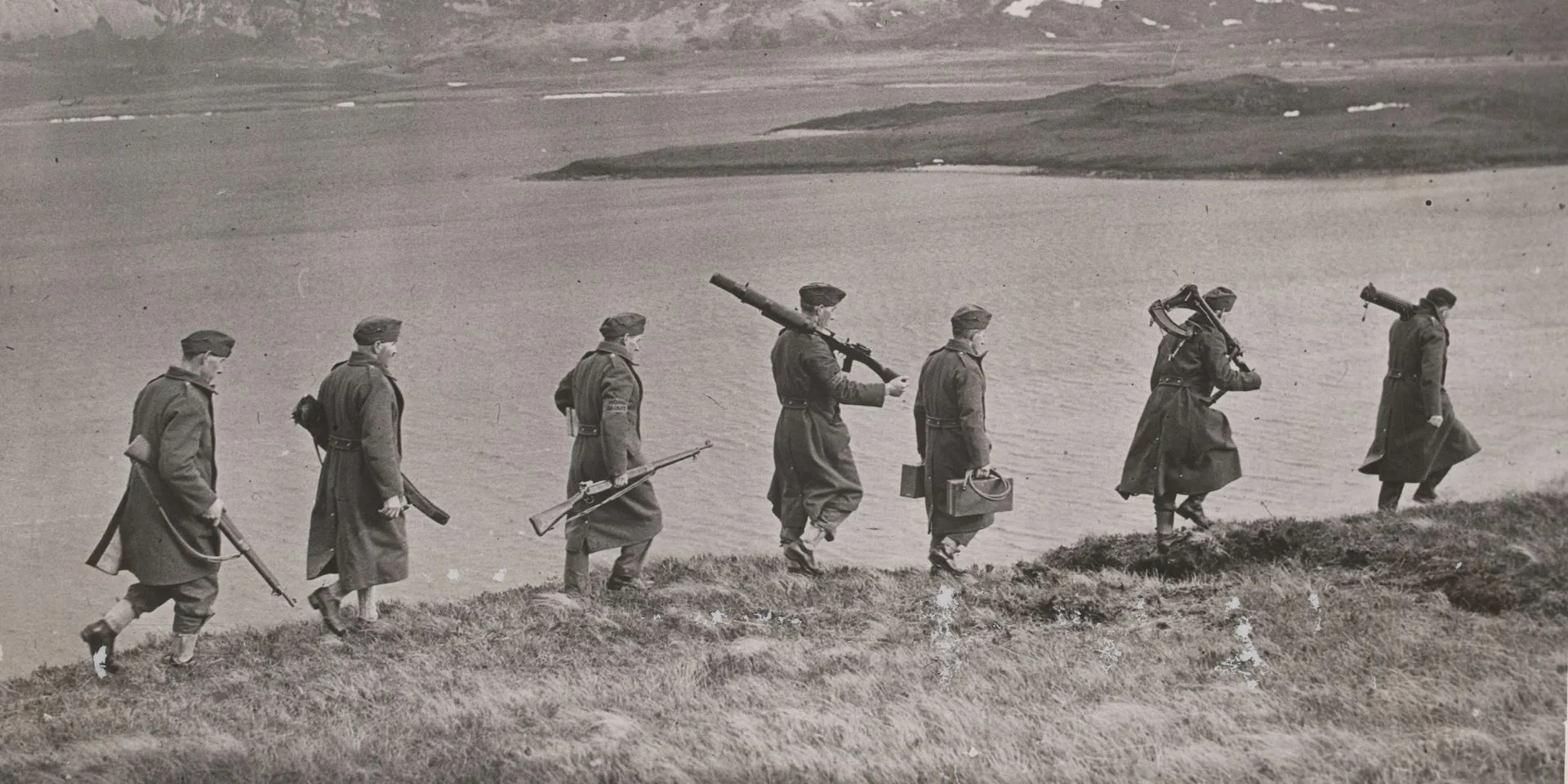 Members of the Home Guard marching alongside a riverbank