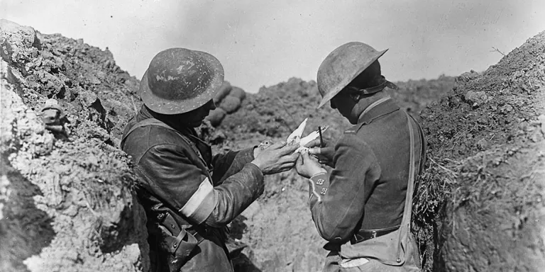 HM Pigeon Service fixing a message to a bird before leaving a trench,  1917