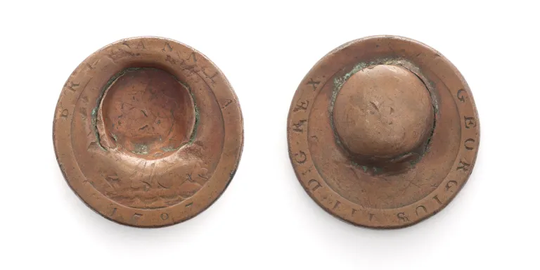 Front and back of a penny dented by a musket ball during the Battle of Waterloo, 1815 