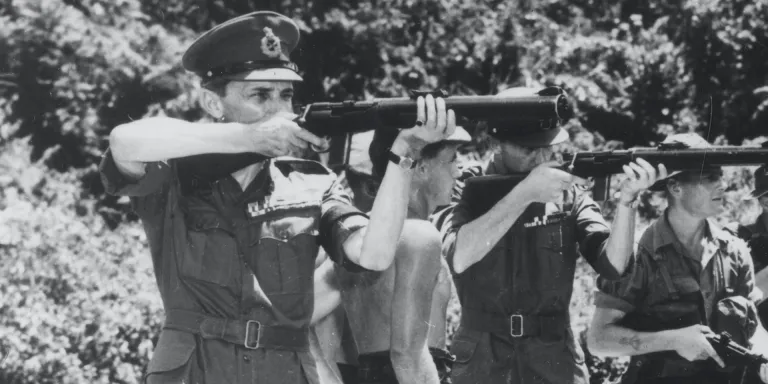 General Sir Gerald Templer (left) testing a De Lisle machine-gun during a visit to 1st Battalion The Gordon Highlanders, south Perak, 1952