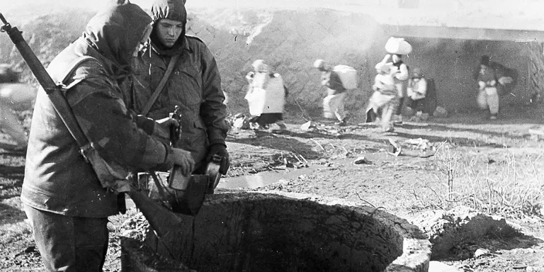 Members of The Middlesex Regiment, wrapped against the bitter Korean winter, draw water from a well, 1951