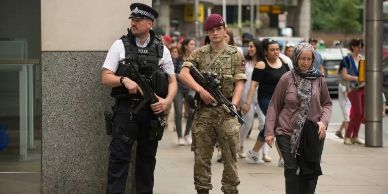 A soldier of 2nd Battalion, The Parachute Regiment, patrols with a police officer during Operation Temperer, 28 May 2017