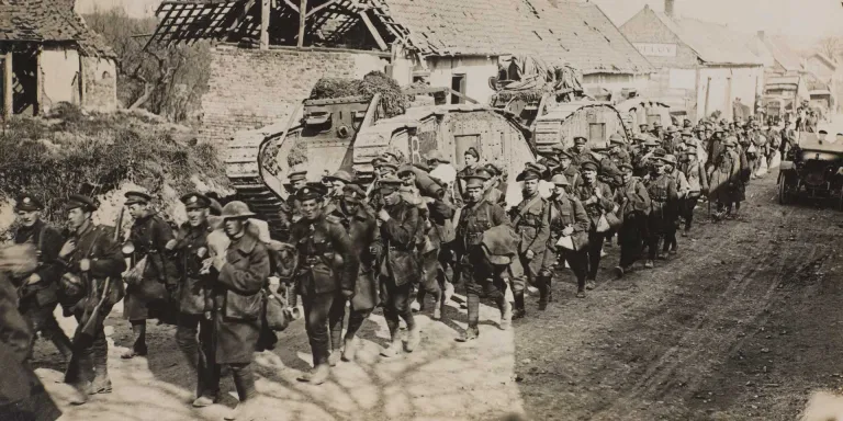 Troops passing tanks on a road, Spring 1918