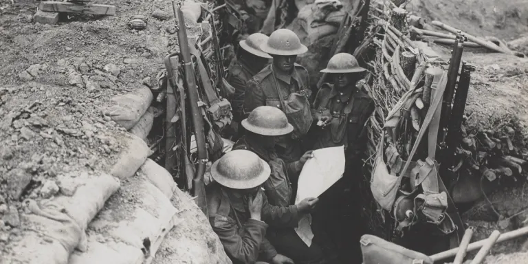 Soldiers reading a newspaper in the trenches, c1916