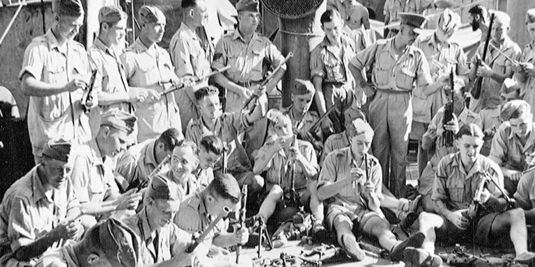 1st Battalion The Durham Light Infantry cleaning weapons on board the 'Winchester Castle', July 1943