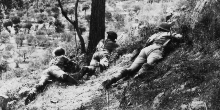 Soldiers of the 6th Royal Inniskilling Fusiliers take cover in an olive grove, Italy, November 1943