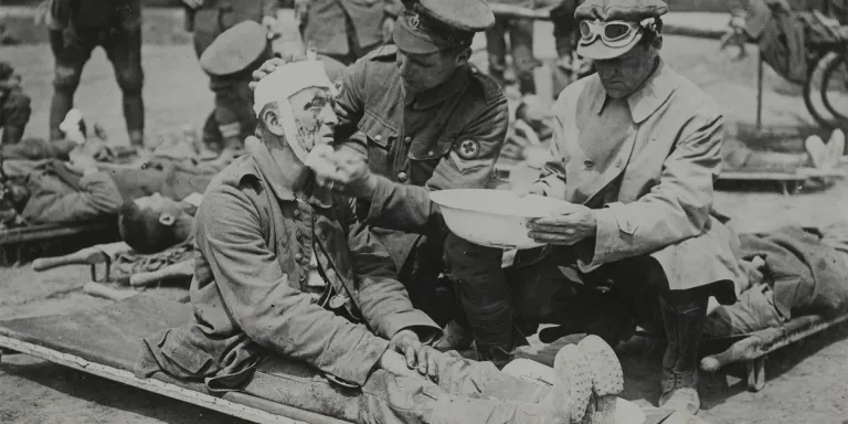 British medical orderly treats a wounded German soldier, c1916
