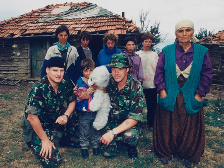 Soldiers with a refugee Kosovo Albanian family, 1999